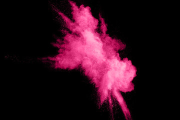Abstract pink powder splatter on black background.Freeze motion of pink color powder explosion.