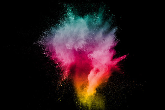 Explosion of color powder on black background. Splash of color powder dust on dark background.