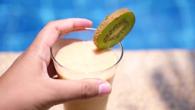 Take a delicious refreshing fruit cocktail on the background of the pool. slow motion. 1920x1080. full hd