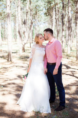 Happy wedding couple hugging and kissing. Beautiful young bride and groom, just married. Couple in love. Shallow focus and some noise.