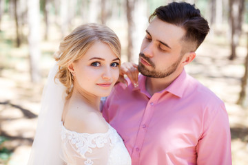 Fototapeta premium Happy wedding couple hugging and kissing. Beautiful young bride and groom, just married. Couple in love. Shallow focus and some noise.