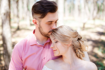 Happy wedding couple hugging and kissing. Beautiful young bride and groom, just married. Couple in love. Shallow focus and some noise.