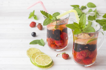 Cocktail with black currant, strawberry, mint and lime. Cooling summer drink.