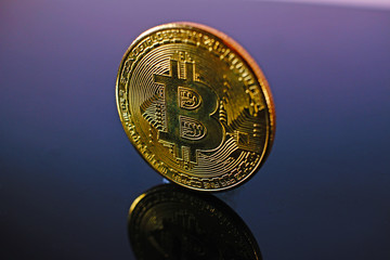 Bitcoin money crypto currency coin on reflective colorful background