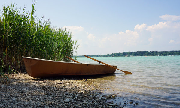 altes ruderboot an kiesstrand im sonnenschein
