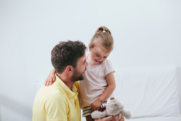 Father and daughter playing on bed