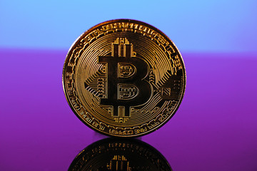 Bitcoin money crypto currency coin on reflective colorful background