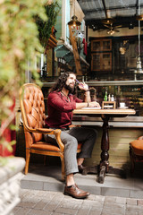 Creative thoughts. Nice creative man sitting in the cafeteria while looking for new ideas for his project