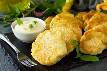Vegan vegetable fritters on a background close-up of slate cutting board. Fried vegetarian cutlets or pancakes. The concept of fast food.