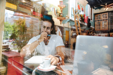 Distance work. Smart nice man sitting in the cafe while working there