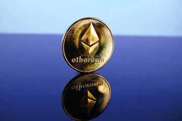 Etherum money crypto currency coin on reflective colorful background
