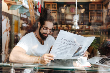 Morning press. Smart handsome man holing a newspaper while reading morning news
