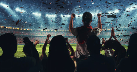 Fans celebrating the success of their favorite sports team on the stands of the professional stadium while it's snowing