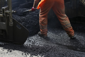 Workers on a road construction, industry and teamwork. builders workers at asphalting paver machine during Road street repairing works