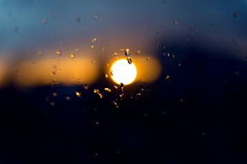 Obraz na płótnie Canvas Sunset after the rain through the glass with droplets. The evening sky.