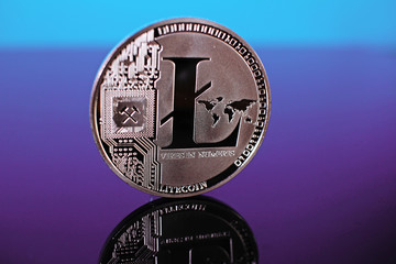 Litecoin crypto currency coin on reflective colorful background