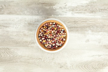 Cheerful and Colorful dried Indian Corn on light wooden surface as decoration for Thanksgiving Table, Halloween, and the Fall Season.