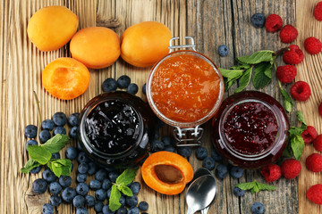 assortment of jams, seasonal berries, apricot, mint and fruits. marmalade or confiture
