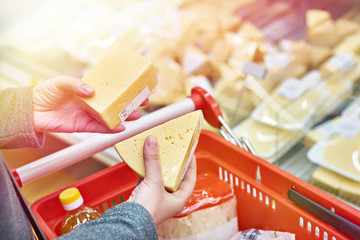 Hands with pieces of cheese in store