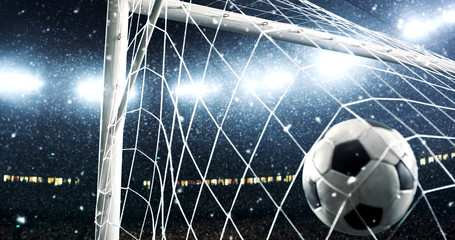 Photo of the ball that flies into a goal on a professional soccer stadium while it's snowing