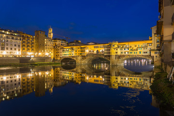 Night riverside scenery of Arno river, Tuscany architectures style and Ponte Vecchio bridge in Florence, Italy.