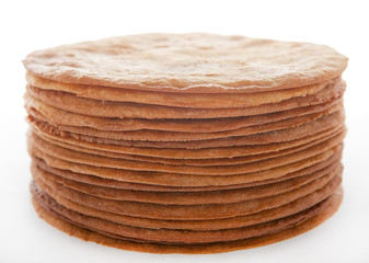 Dry baked honey cakes for the cake in a pile on a white background.