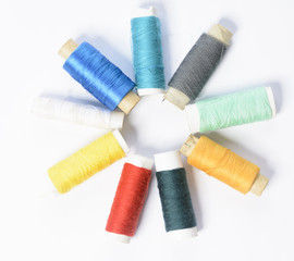color threads for sewing on a white textured background