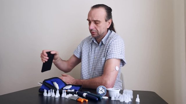 A man hands brings to the hand the smartphone for measuring glucose in the blood