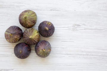 Fresh figs on white wooden background, top view. From above, overhead. Copy space.