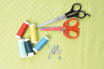 Scissors and threads on fabric, top view Tailoring equipment