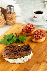 Medium rare grilled Steak Ribeye on serving board block on wooden background