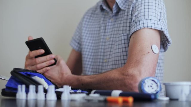 A man hands brings to the hand the smartphone for measuring glucose in the blood