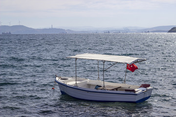 Obraz premium Perspective shot of wooden fishing boat on the sea at sunset of horizon