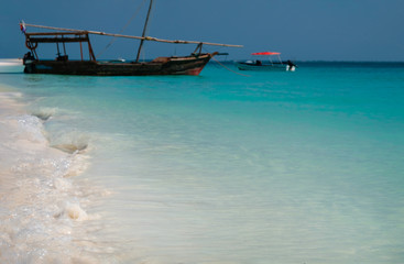 Fototapeta na wymiar A wooden pirate ship by the shore. The coast of the Indian Ocean. Zanzibar of Tanzania