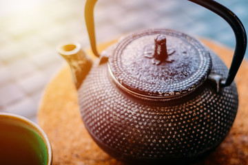 Obraz na płótnie Canvas Green tea in teapot and cup closeup