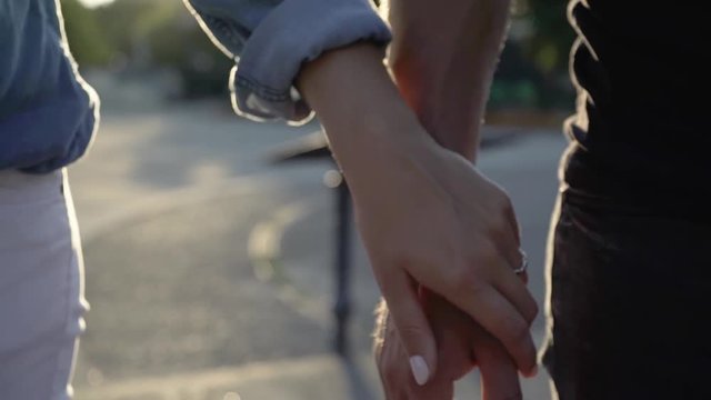 Close up shot of woman's hand touching her man's hand and holding it strongly.