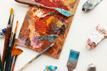 Vintage brushes with oil paint lie on the desktop. A set of tools for the artist
