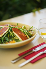 Salad with rucola, vegetables, oranges with fried cheese and greens.