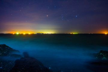 Fototapeta na wymiar 白波寄せる夜の海で星を眺めるセルフポートレート