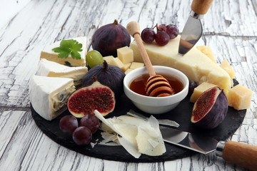 Cheese plate served with grapes, figs and honey