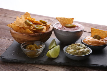 Nachos Tortilla Chips and jalapeños Chili Peppers or Mexican chili peppers with Tomato, Cheese and Guacamole dip