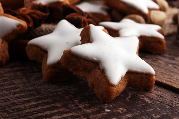 Christmas cookies and spices on brown wooden background.