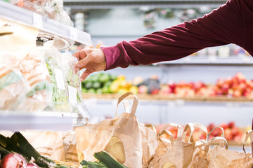 close up customer hand buying some healthy fresh food vegetables in eco market