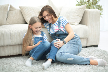 Obraz premium mother and her little daughter use a smartphone to view the photo