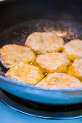 Crab and Fish Cakes Cooking in a Blue Pan