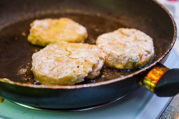 Closeup of Frying Crab, Fish and Sweet Potato Cakes (Latkes) in a Frying Pan