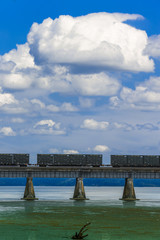 train carts on bridge large clouds
