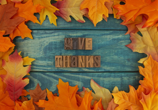 Give Thanks Background with Fall Leaves on Blue Wood
