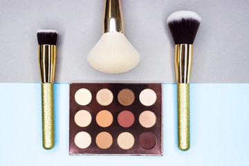 Brushes and makeup shadows on a beautiful background