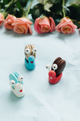 Creative snail decorations with delicious macaroons on blue table 